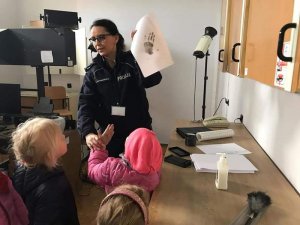 Policjantka robi przedszkolakom pamiątkowe odciski dłoni