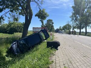 Na zdjęciach przedstawione jest miejsce zdarzenia po wypadku drogowym. Jeden z pojazdów znajduje się w przydrożnym rowie, drugi na środku pasów ruchu. Oba pojazdy posiadają poważne uszkodzenia powypadkowe.